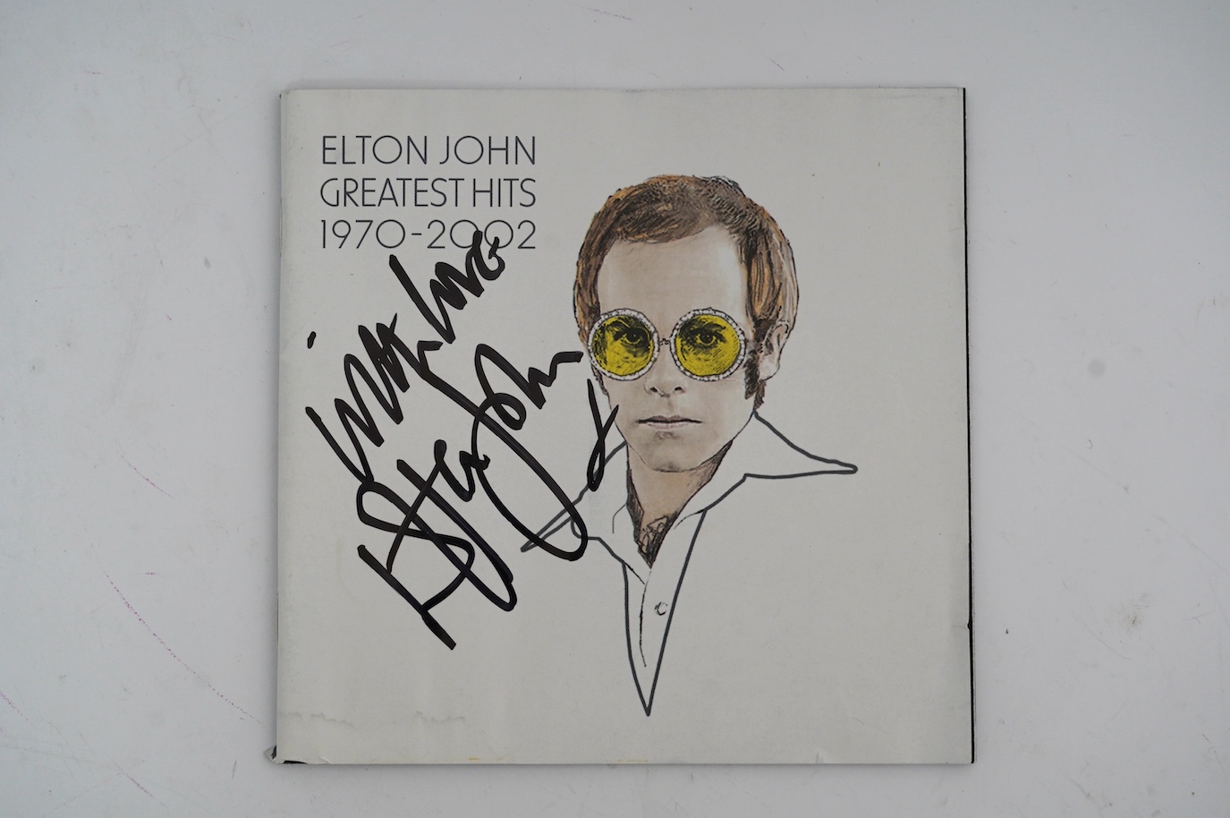 A signed Elton John CD; Greatest Hits 1970-2002, signed to the cover of the booklet in black ink, purchased at charity auction from Rachael Watkyns of the Tiny Box Company as a fundraiser to support makers of fair trade